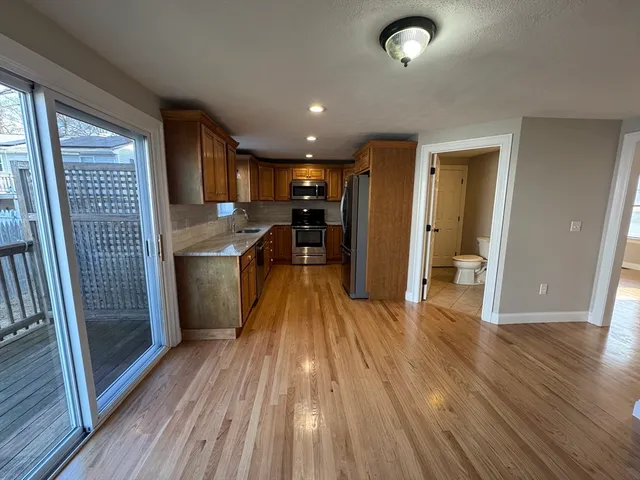 a view of a kitchen with wooden floor and a sink