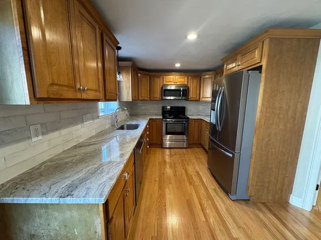 a view of a kitchen with a sink and wooden floor