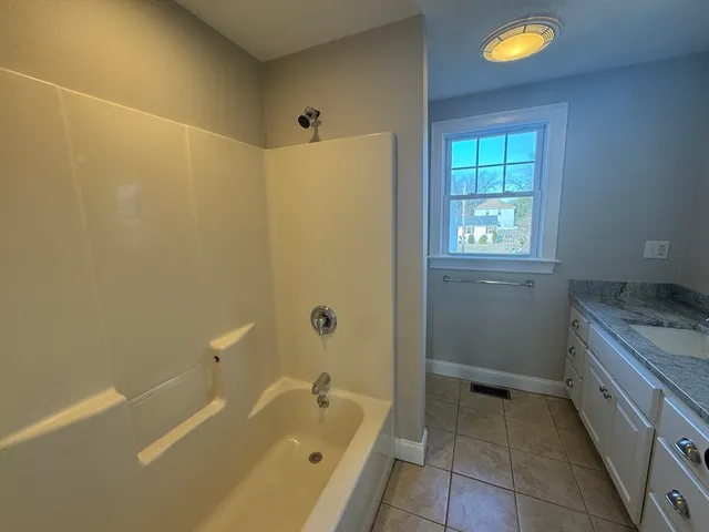 a bathroom with a granite countertop sink a toilet and bathtub
