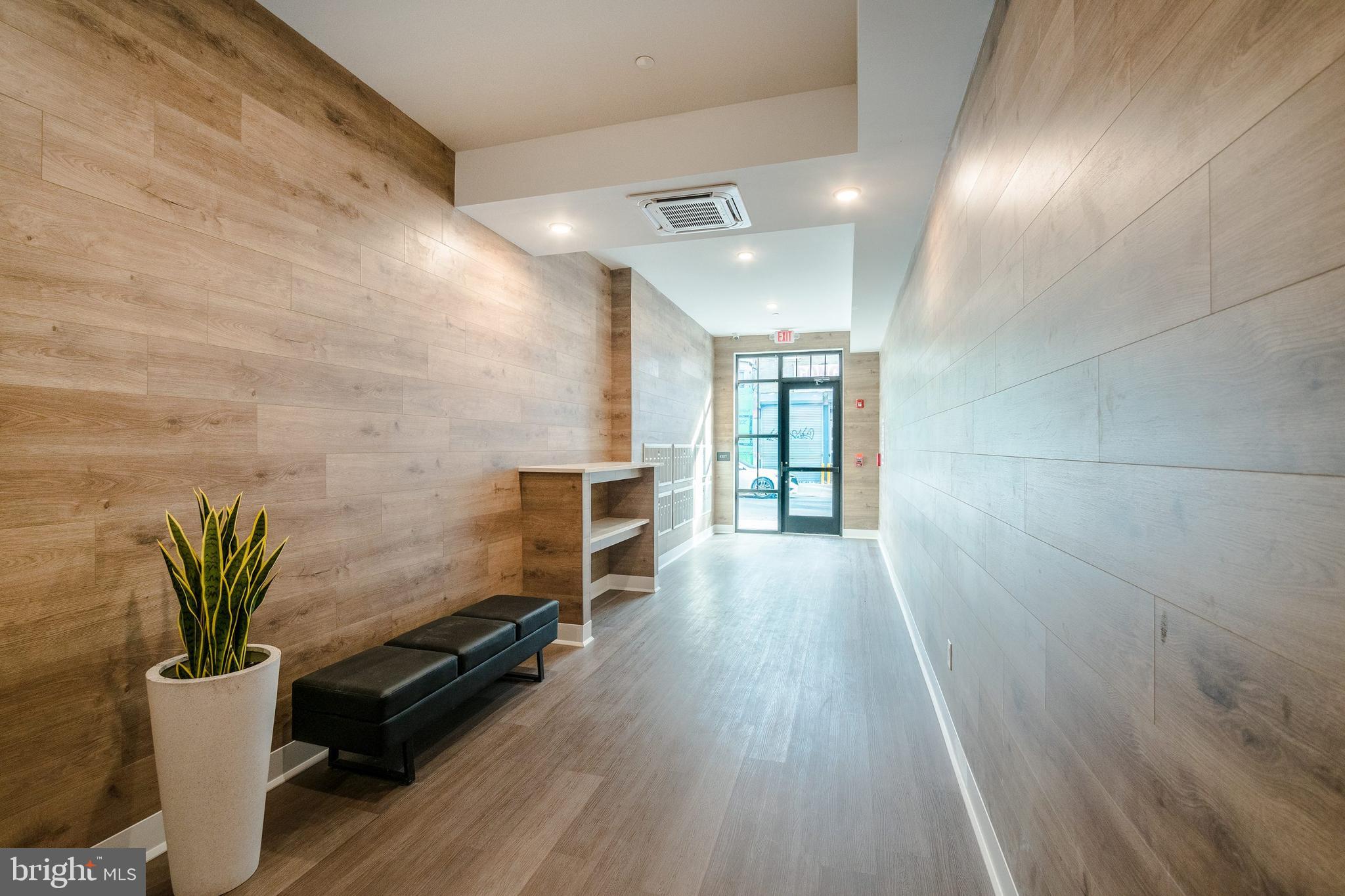 1439 Federal Street, Unit 211 Philadelphia, PA 19146 - Photo 17 of 21 a view of a hallway with wooden floor and glass door