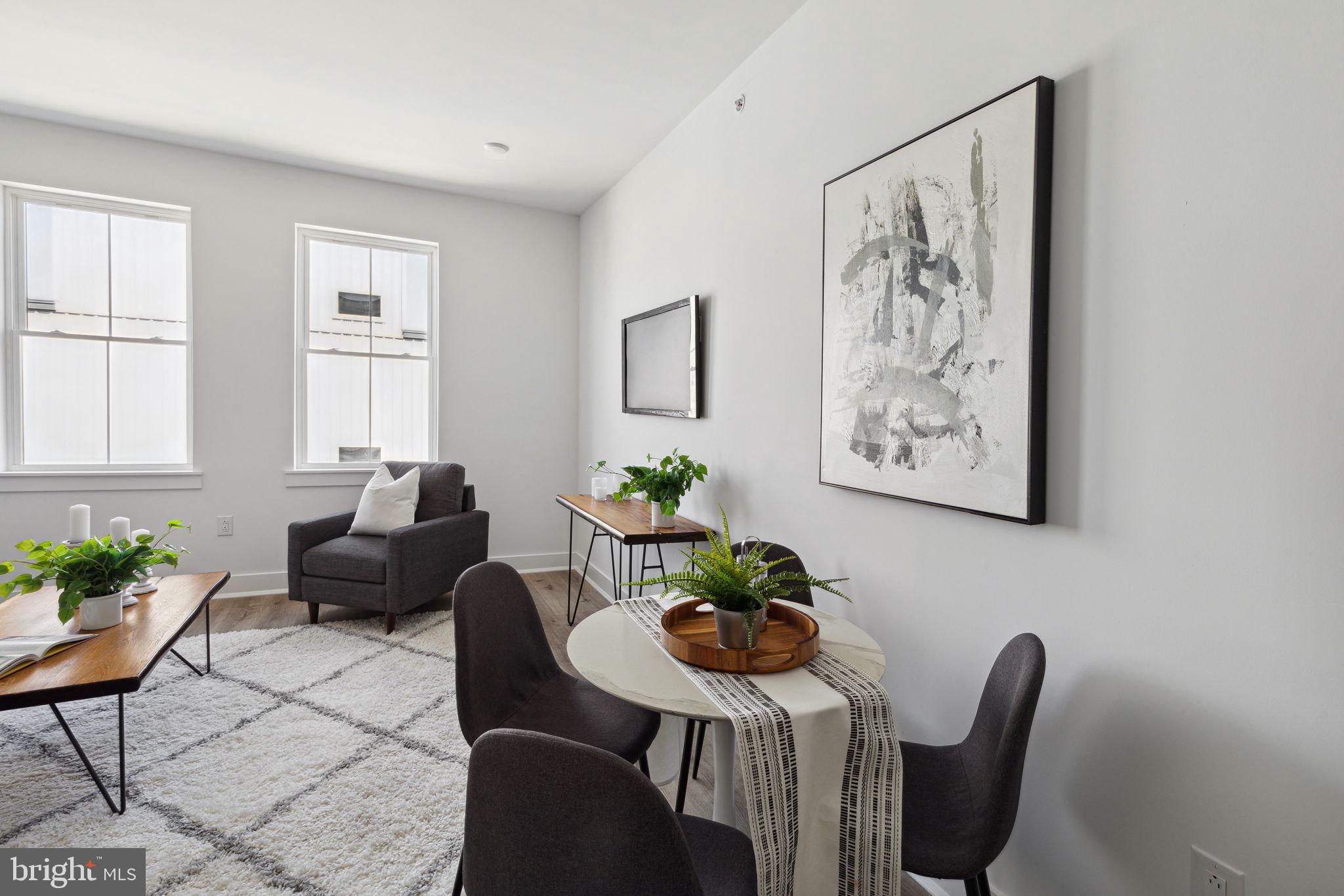 1439 Federal Street, Unit 211 Philadelphia, PA 19146 - Photo 4 of 21 a living room with furniture potted plant and a wooden floor