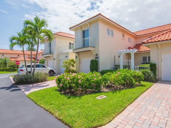 a front view of a house with a garden and plants