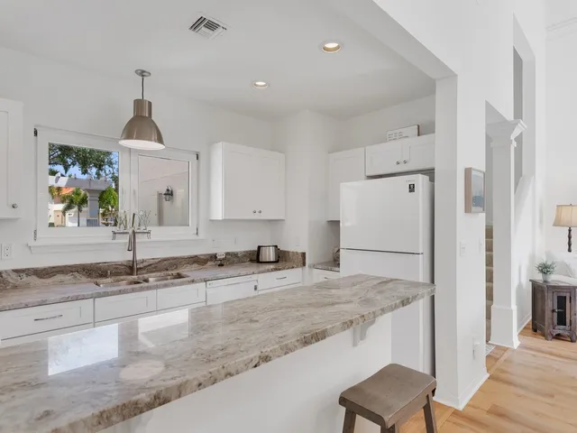 a kitchen with stainless steel appliances granite countertop a sink and a refrigerator