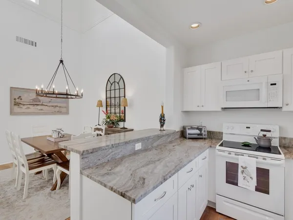 a kitchen with granite countertop a sink a stove and cabinets
