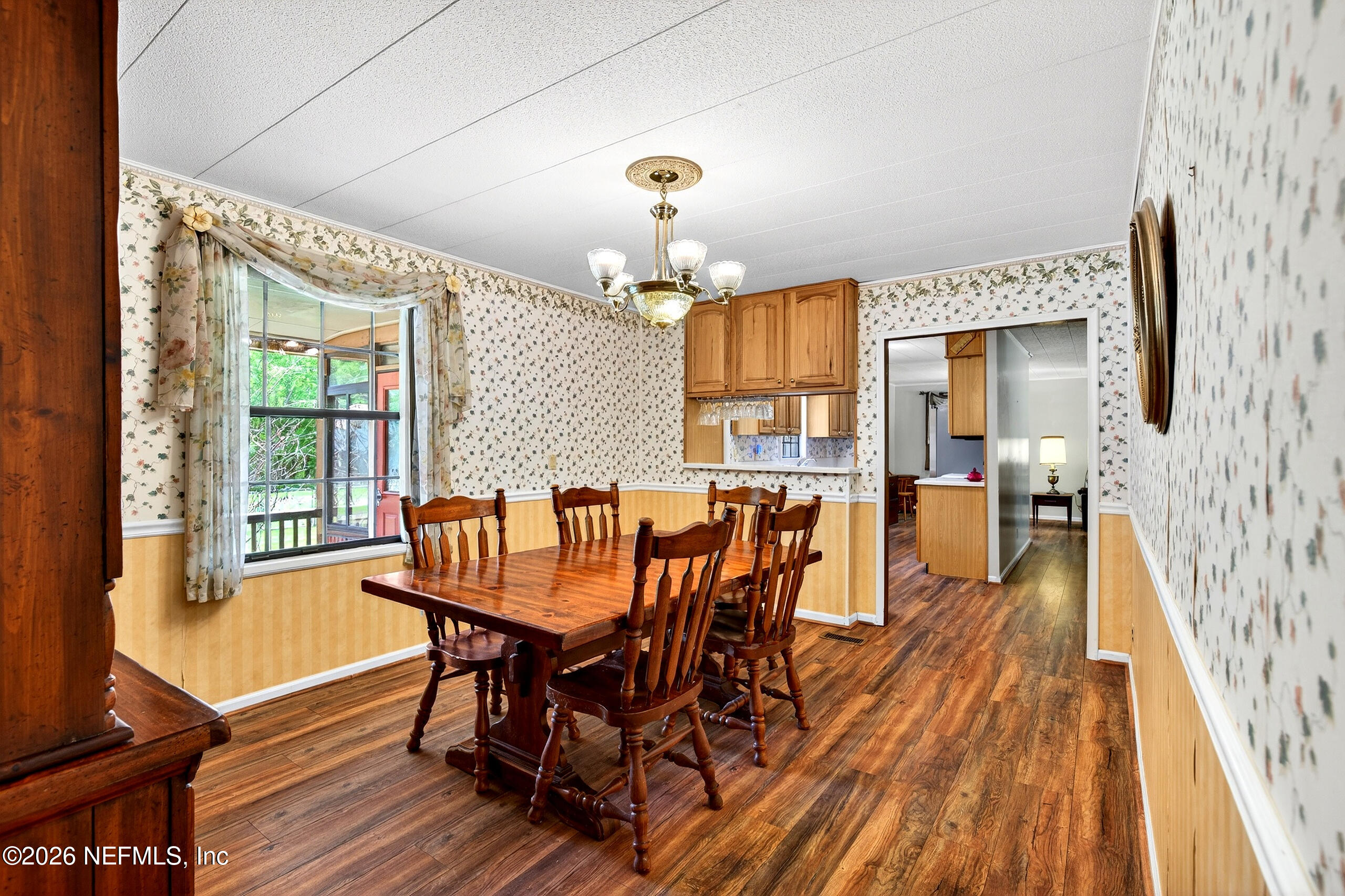 43122 Pineridge Drive Callahan, FL 32011 - Photo 11 of 46 a dining room with furniture a chandelier and wooden floor