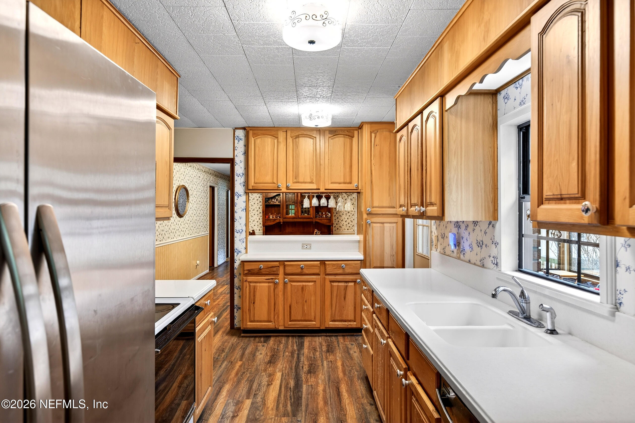 43122 Pineridge Drive Callahan, FL 32011 - Photo 10 of 46 a kitchen with stainless steel appliances granite countertop a refrigerator a oven and a sink with wooden floor