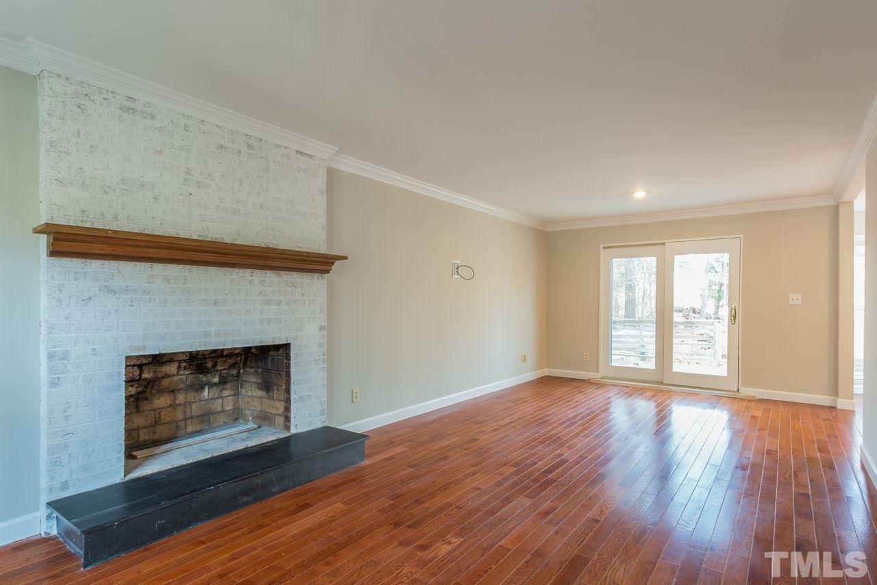 307 Winterberry Ridge Drive Durham, NC 27713 - Photo 3 of 19 a view of an empty room with wooden floor fireplace and a window