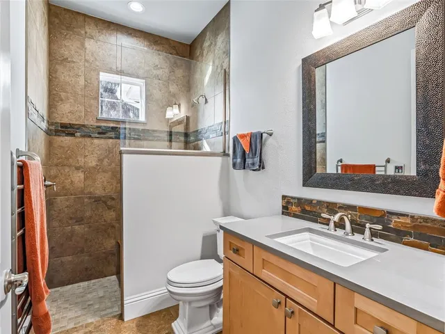 a kitchen with stainless steel appliances granite countertop a sink a stove a dining table chairs and granite counter tops