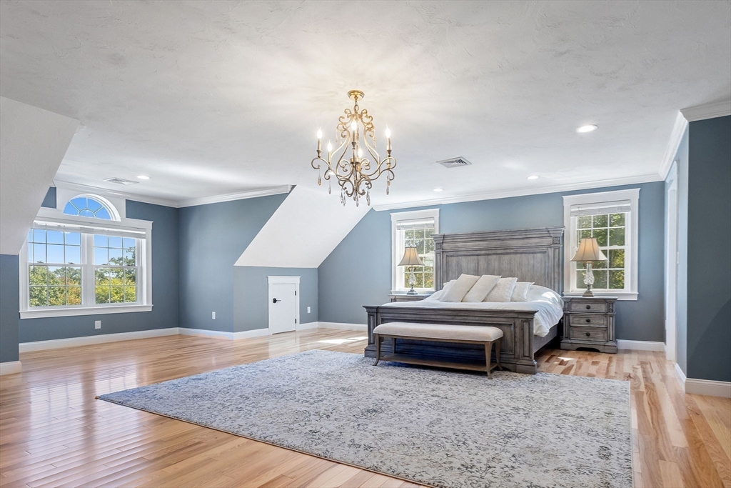 47 Fiske Mill Road Upton, MA 01568 - Photo 24 of 38 a spacious bedroom with a bed and a chandelier
