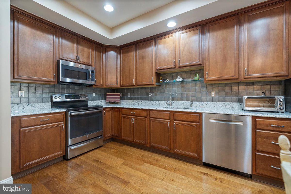 327 Melbourne Way Souderton, PA 18964 - Photo 13 of 44 a kitchen with granite countertop wooden cabinets a stove top oven a sink and dishwasher
