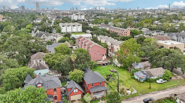 an aerial view of residential houses with outdoor space and trees