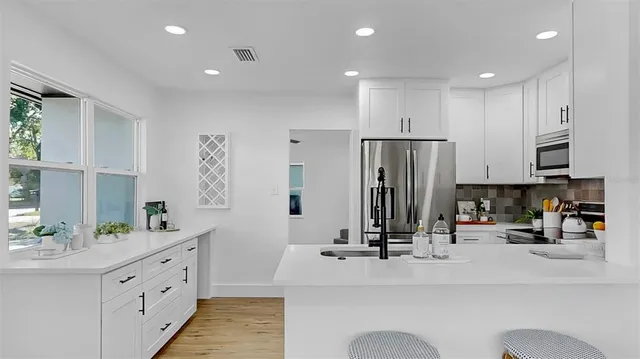 a kitchen with stainless steel appliances kitchen island granite countertop a sink and cabinets