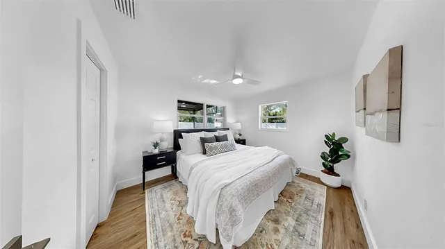 a bedroom with a bed and wooden floor