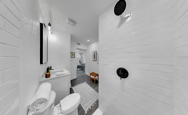 a bathroom with a granite countertop sink mirror vanity and toilet