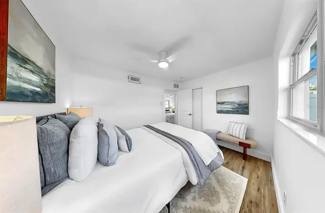 a bed room with a bed and a painting on the wall