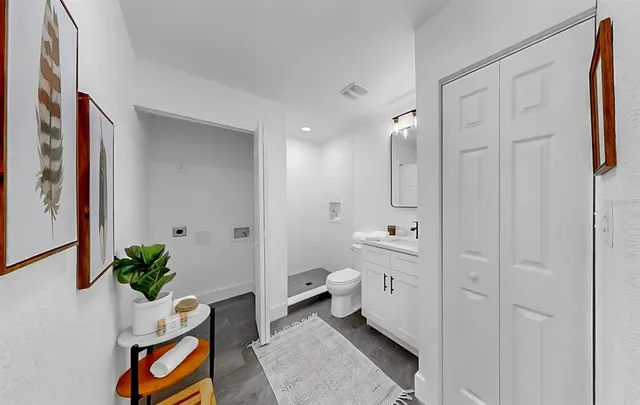 a spacious bathroom with a double vanity sink a toilet and a shower curtain