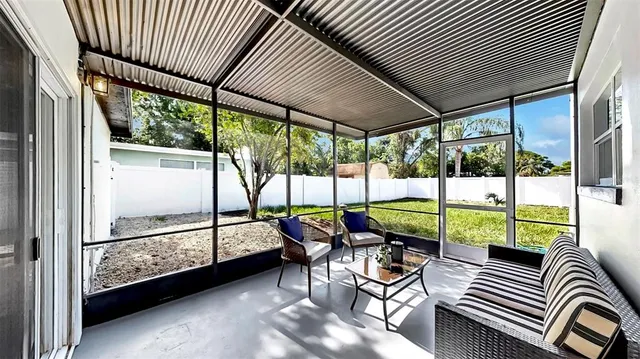 a view of a patio with table and chairs and wooden floor next to a yard