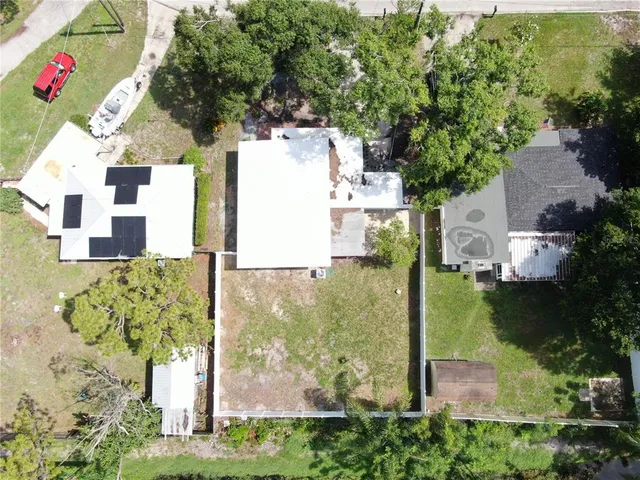 an aerial view of residential house with outdoor space and trees all around