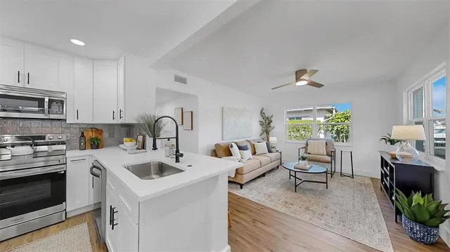 a kitchen with a sink cabinets and wooden floor