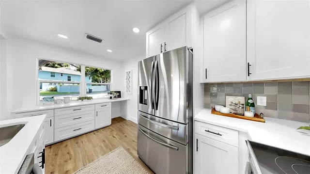 a kitchen with white cabinets and stainless steel appliances