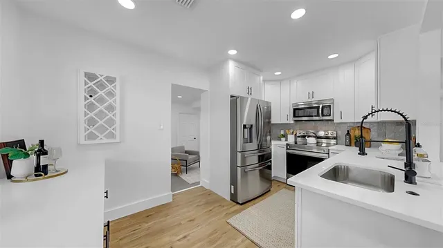 a kitchen with stainless steel appliances granite countertop a refrigerator and a sink