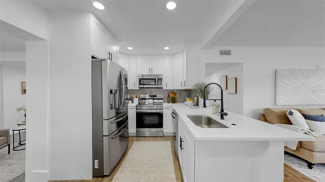 a kitchen with refrigerator a sink and cabinets