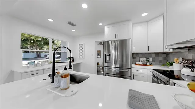 a kitchen with refrigerator cabinets and a sink