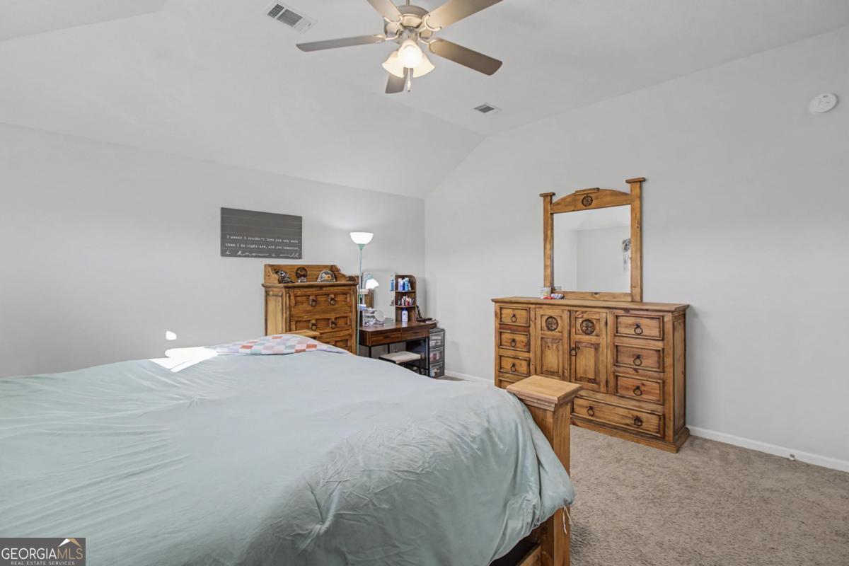 263 Brandonwood Road Northeast Ludowici, GA 31316 - Photo 13 of 34 a bedroom with a bed and a chandelier
