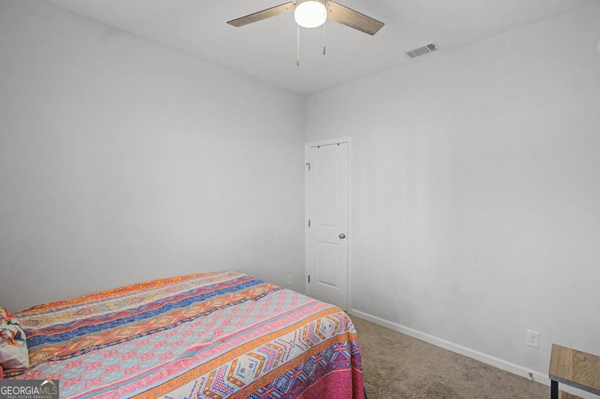 263 Brandonwood Road Northeast Ludowici, GA 31316 - Photo 18 of 34 a bedroom with a bed and a chandelier fan