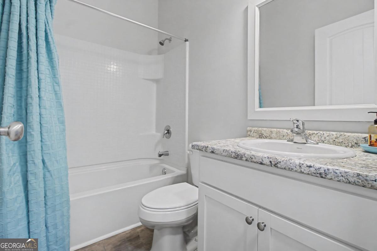 263 Brandonwood Road Northeast Ludowici, GA 31316 - Photo 20 of 34 a bathroom with a granite countertop sink a toilet and shower