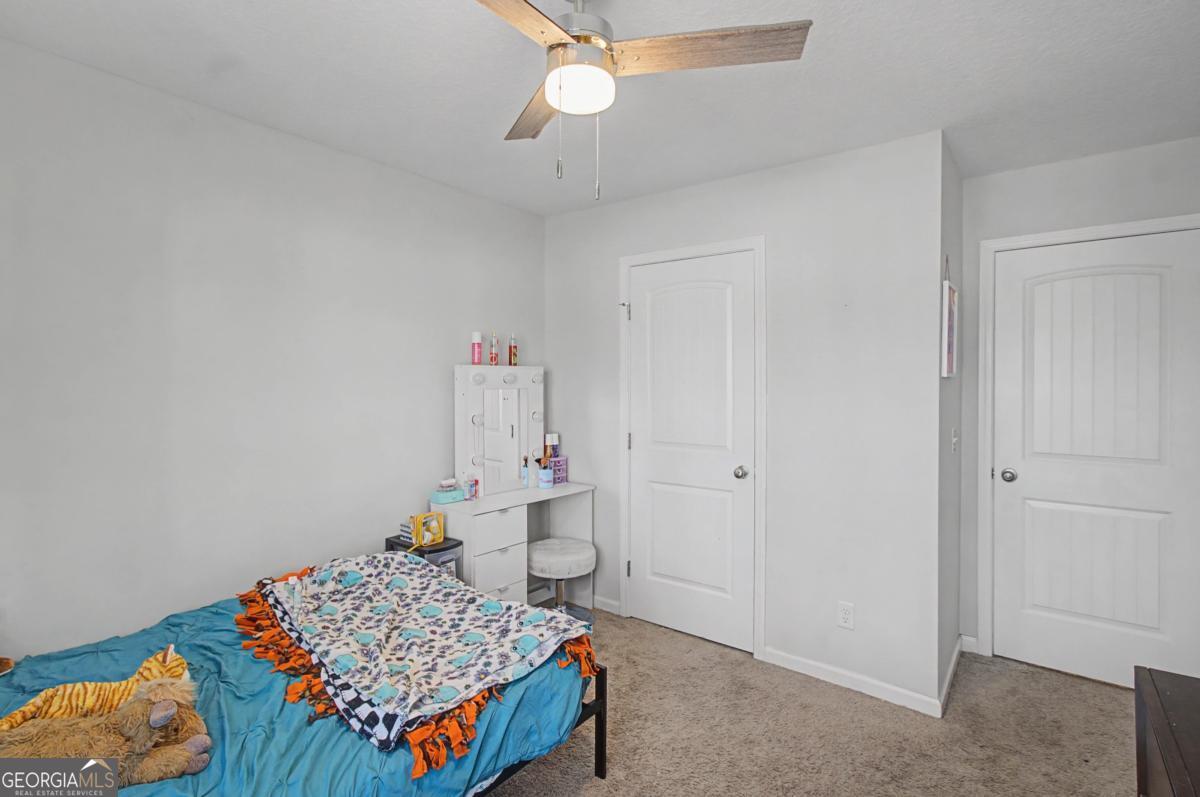 263 Brandonwood Road Northeast Ludowici, GA 31316 - Photo 27 of 34 a bedroom with a bed and a chandelier fan