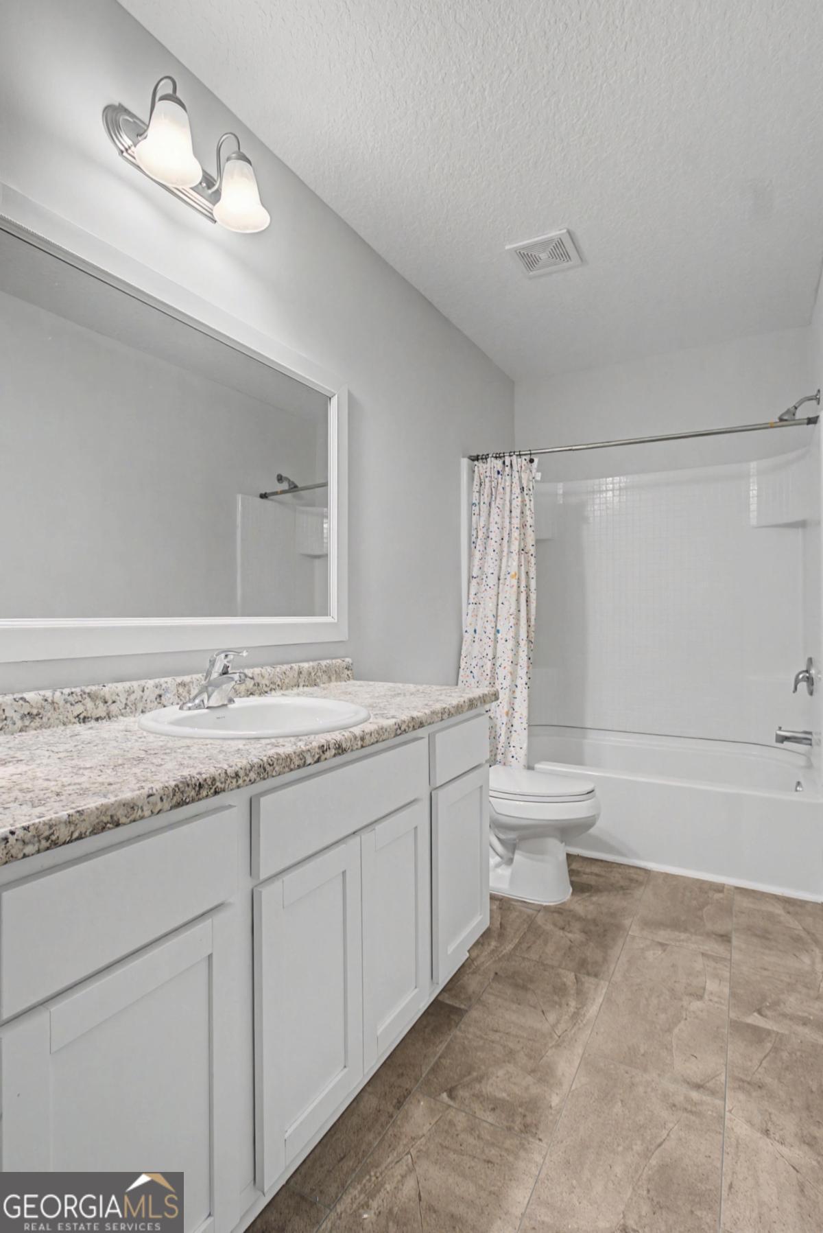 263 Brandonwood Road Northeast Ludowici, GA 31316 - Photo 29 of 34 a bathroom with a granite countertop sink a toilet and bathtub