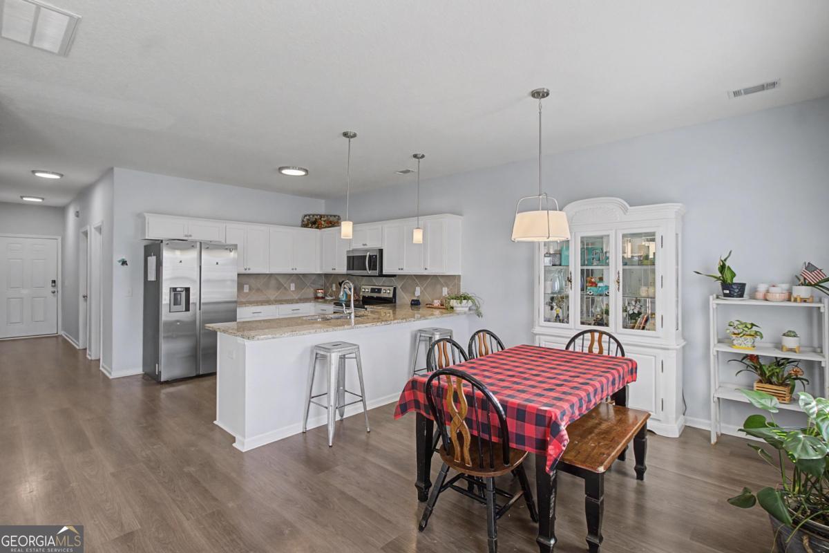 263 Brandonwood Road Northeast Ludowici, GA 31316 - Photo 5 of 34 a dining room with stainless steel appliances kitchen island a table chairs and a kitchen view