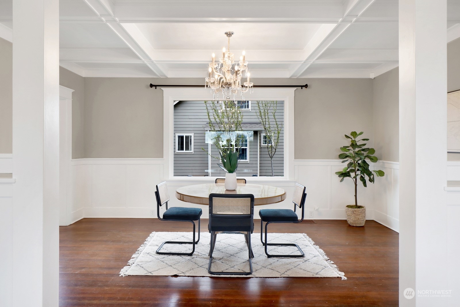 2120 12th Street Anacortes, WA 98221 - Photo 7 of 40 a dining room with wooden floor a chandelier a wooden table and chairs