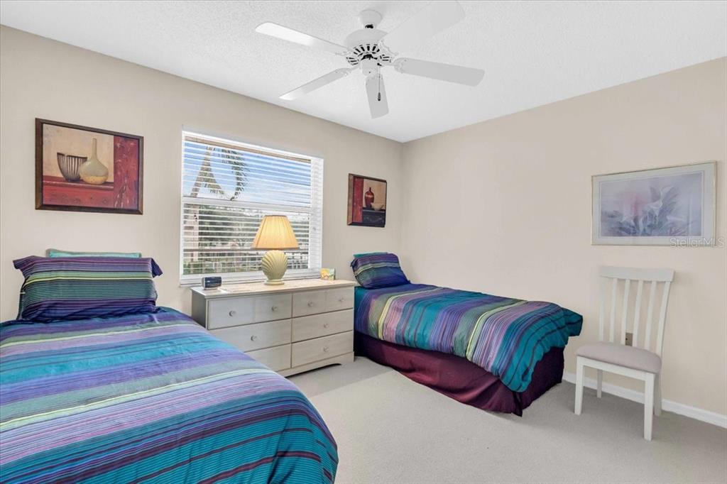 6505 Stone River Road, Unit 202 Bradenton, FL 34203 - Photo 12 of 55 a bedroom with a large bed and a chandelier
