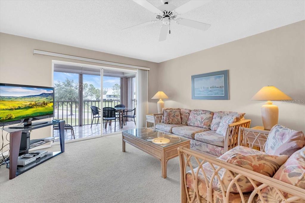 6505 Stone River Road, Unit 202 Bradenton, FL 34203 - Photo 22 of 55 a living room with furniture and a flat screen tv
