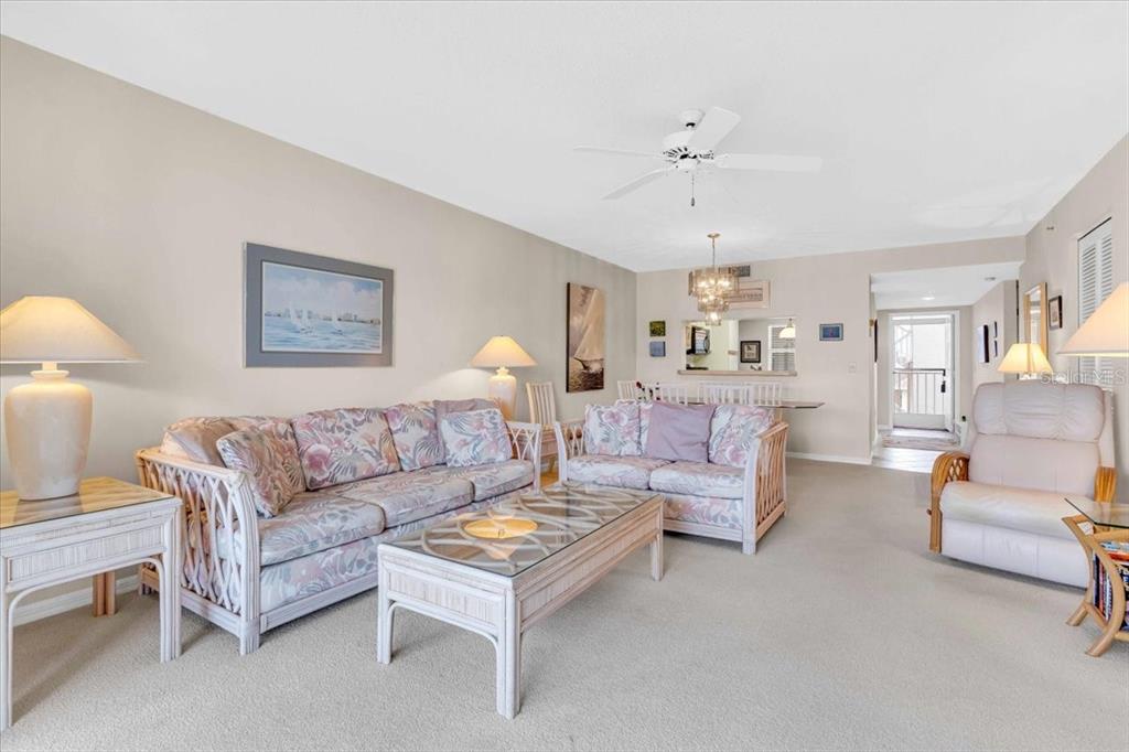 6505 Stone River Road, Unit 202 Bradenton, FL 34203 - Photo 23 of 55 a living room with furniture and a chandelier