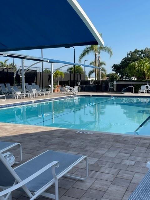 6505 Stone River Road, Unit 202 Bradenton, FL 34203 - Photo 41 of 55 a view of a backyard with table and chairs under an umbrella