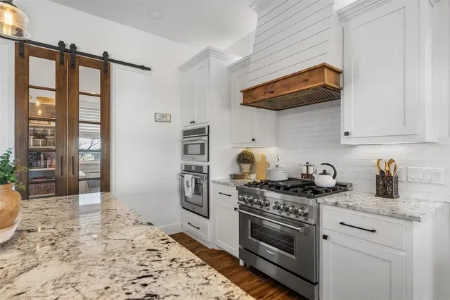 a kitchen with stainless steel appliances granite countertop a stove a sink and a refrigerator