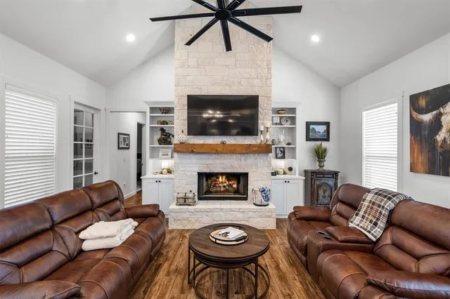 a living room with furniture a fireplace and a flat screen tv
