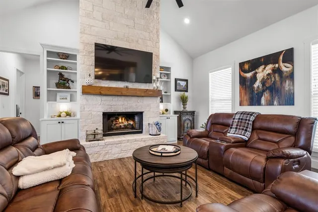a living room with furniture a fireplace and a flat screen tv