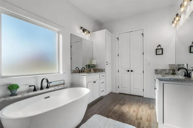 a bathroom with a double vanity sink and mirror with shower