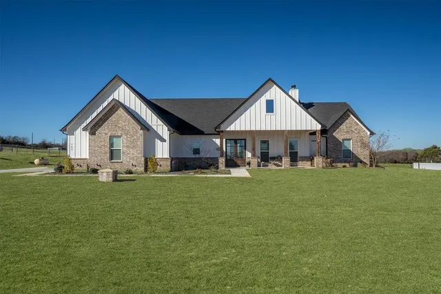 a front view of a house with a yard and porch