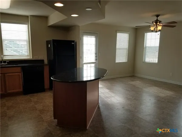 a kitchen with kitchen island a sink stainless steel appliances and window