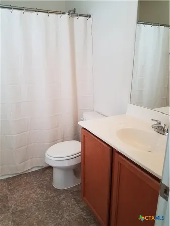 a bathroom with a sink a toilet and a mirror