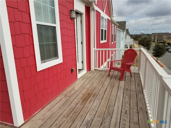 a balcony with wooden floor and bench