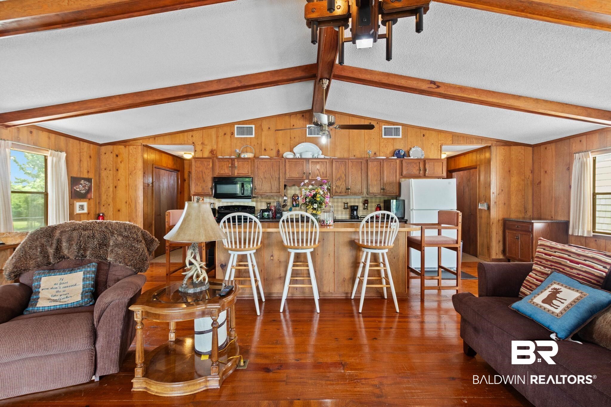8153 Bryant's Lndg Road Stockton, AL 36579 - Photo 21 of 87 Open-concept living space featuring wood-finish flooring, exposed wood ceiling beams, and wood-paneled walls