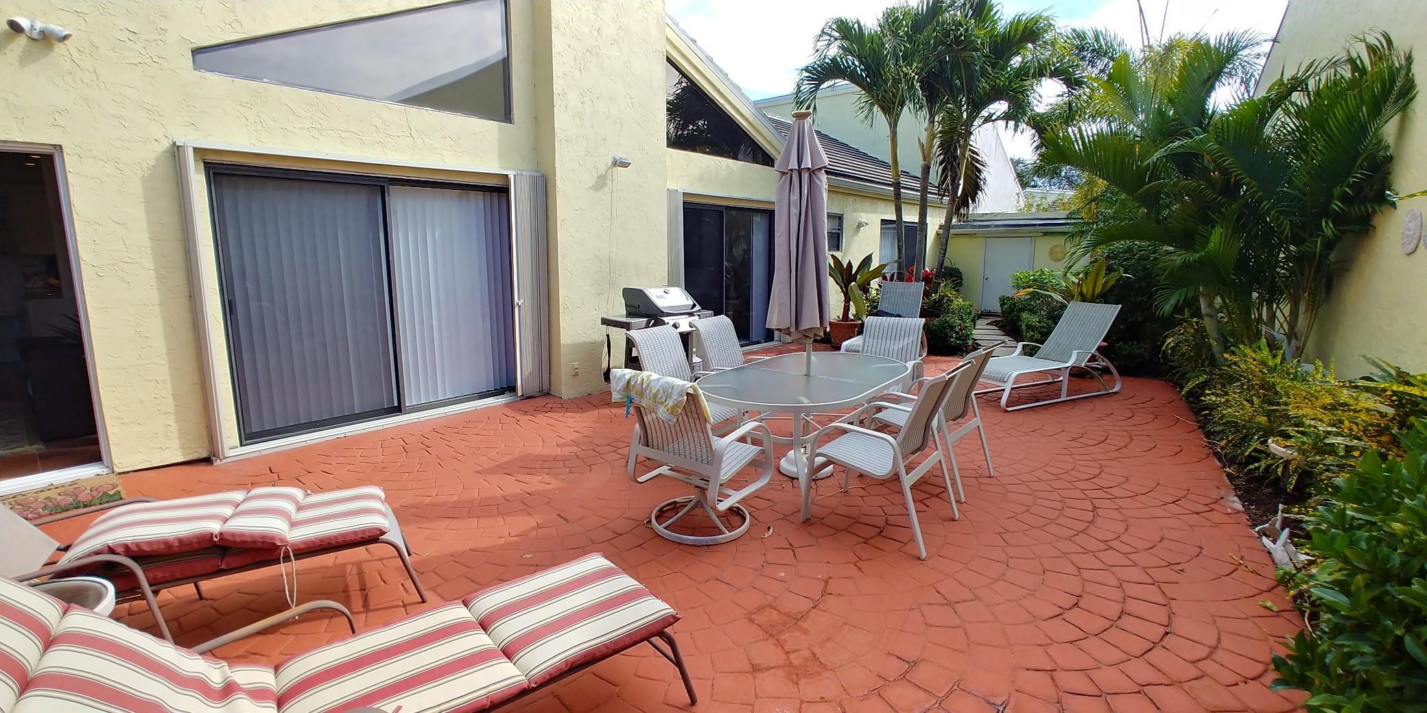 17042 Traverse Circle Jupiter, FL 33477 - Photo 8 of 30 a backyard of a house with table and chairs