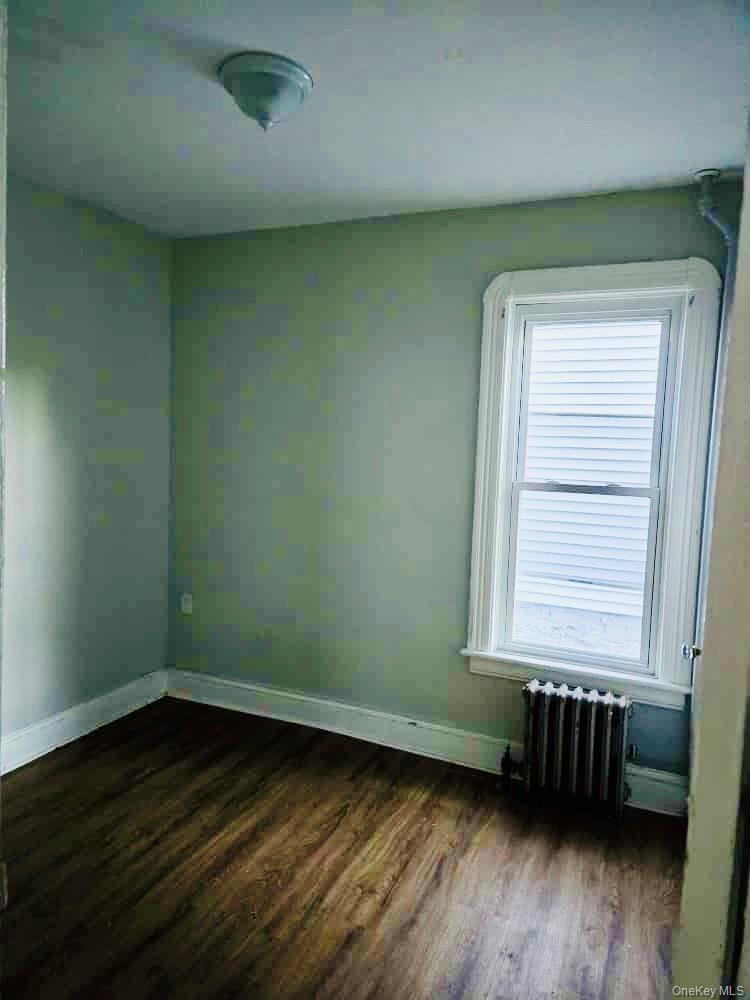 515 Summit Avenue Schenectady, NY 12307 - Photo 12 of 15 Spare room with dark wood-type flooring and radiator