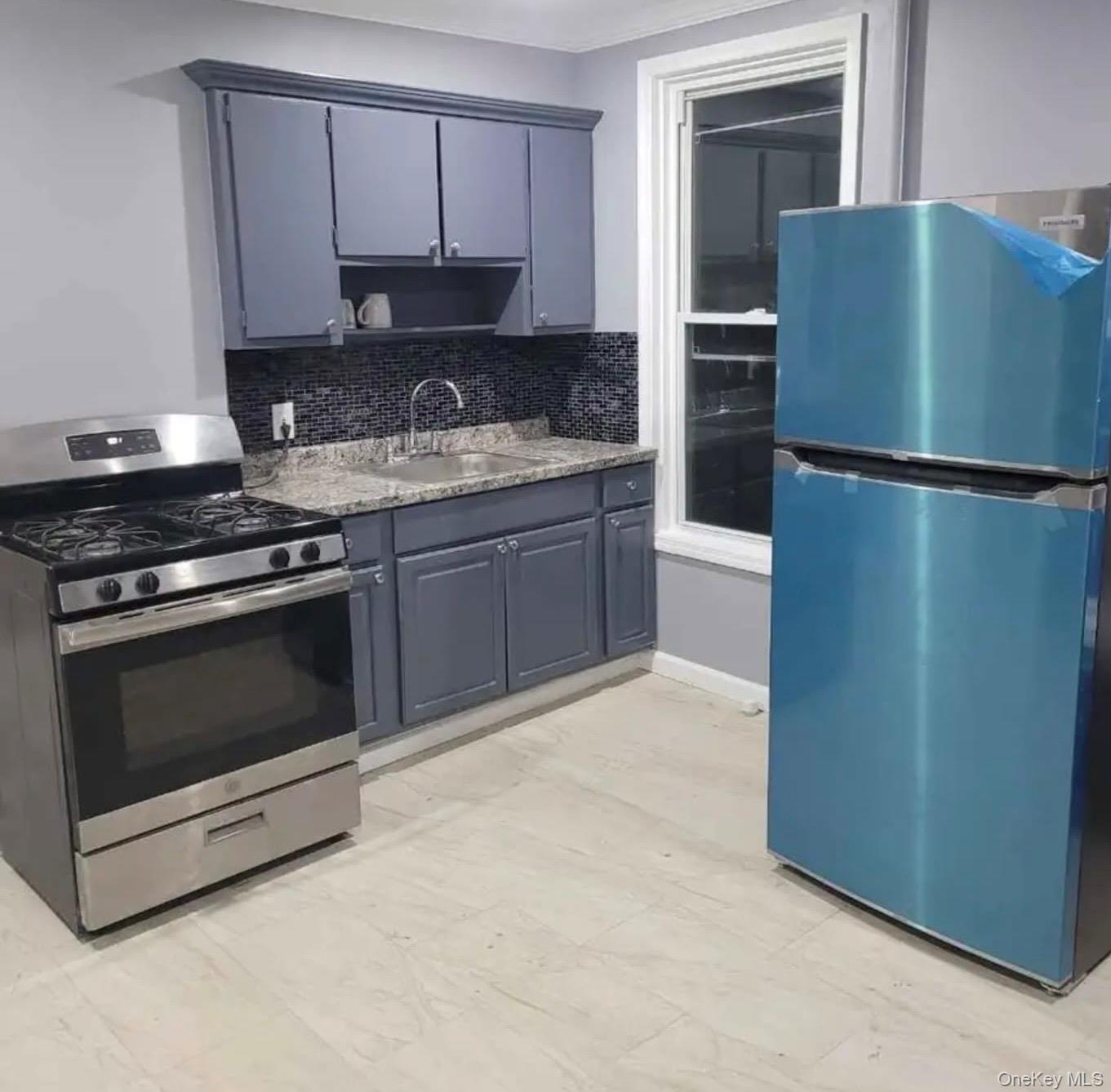 515 Summit Avenue Schenectady, NY 12307 - Photo 8 of 15 Kitchen featuring appliances with stainless steel finishes, a sink, tasteful backsplash, and light marble finish floors